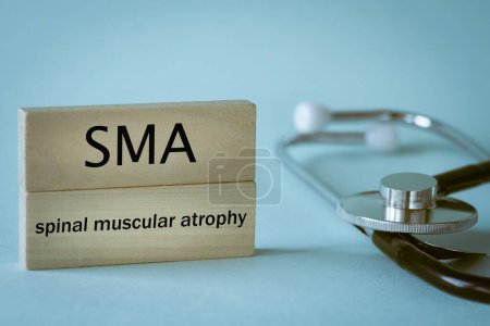Photo for SMA Rare disease abbreviation Spinal Muscular Atrophy written on wooden blocks along with medical stethoscope, health concept, close up - Royalty Free Image