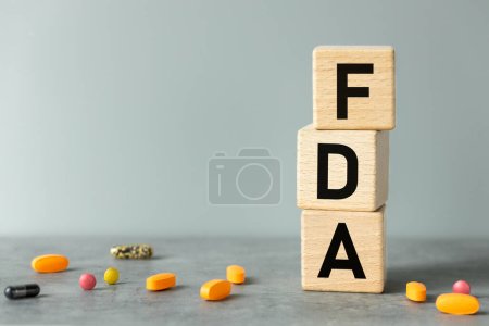 FDA, Worte auf Holzklötzen. Schöne graue Hintergrund, Geschäftskonzept, Bestätigung der Inspektion und Registrierung von Medikamenten und medizinischen Geräten in der Medizin verwendet, Kopierraum