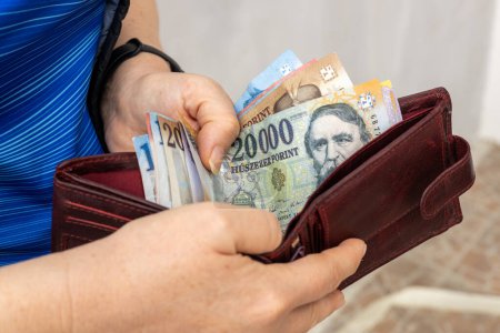Forint hongrois, Femme tient portefeuille avec de l'argent en main, Concept financier et budgétaire