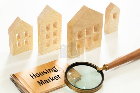 Wooden miniature houses, written Housing market. magnifying glass, Forecast new trends and changes in housing trends. real estate market review, Mortgage rate. Economic analyzes and investment plans
