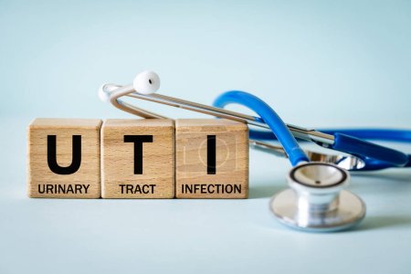 Photo for Medical stethoscope and wooden blocks with the medical abbreviation UTI for Urinary Tract Infection, Medical concept, beautiful blue background - Royalty Free Image