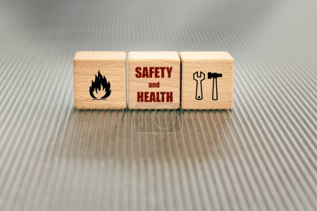 Occupational health and safety, Concept of safety at work, accident insurance, wooden blocks with the text safety and health, icons of work tools, attention fire danger