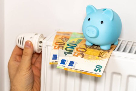 Téléchargez les photos : Coûts de chauffage des appartements en hiver dans l'Union européenne, concept énergétique et économique, main dévissant le radiateur, tirelire et euro argent - en image libre de droit