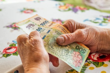 Una pensionista argentina tiene una pensión en sus manos, inflación en Argentina, situación financiera