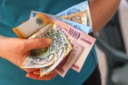 Hungría dinero, Mujer sostiene un puñado de florines húngaros en su mano, varios billetes, concepto financiero