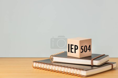 Foto de IEP Individual Education Plan Symbol. Concepto de negocio, programa IEP 504, texto sobre un bloque de madera natural colocado en cuadernos escolares, espacio para copiar, - Imagen libre de derechos