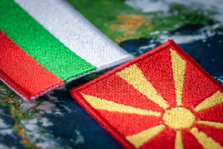 Bulgarien und Mazedonien Flaggen Patches und Ländersymbole auf Globus Hintergrund, Nahaufnahme, Konzept der schwierigen gegenseitigen Beziehungen