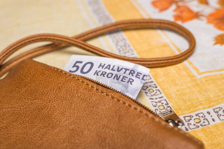 Women's purse with a 50 Danish kroner banknote sticking out, Financial concept, Denmark money, home budget, Cash payment in Scandinavi