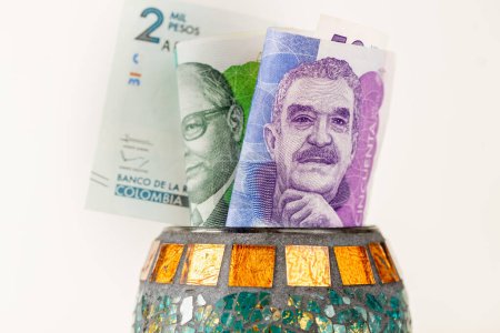Kolumbianisches Geld, 50- und 100-Pesos-Banknoten, die aus einer dekorativen Schale herausragen, Finanzkonzept, Sparen und Wirtschaft