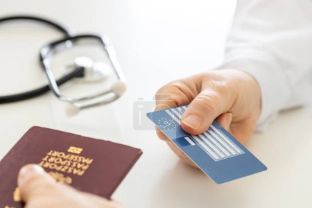 Carte européenne d'assurance maladie remise au médecin au cabinet du médecin, Concept, Assurance voyage, Protection des vacances, Traitement à l'étranger