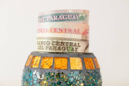 Paraguay money, banknotes sticking out from a decorative bowl, Financial concept, Financial savings of Paraguayans, close up