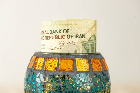 Geld aus dem Iran, Banknote, die aus einer dekorativen Schale herausragt, Finanzkonzept, Finanzersparnisse, iranische Bank