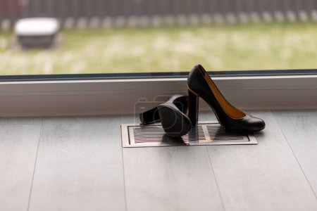 Photo for Black high heel pumps in front of a window and on a light floor. High quality photo - Royalty Free Image