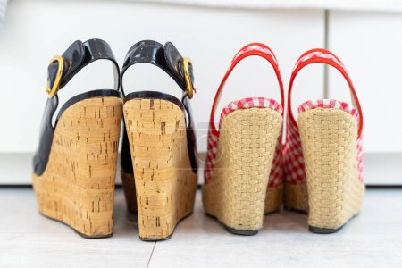 Photo for Red and Black pair of open shoes with a high wedge heel in front of a closet. High quality photo - Royalty Free Image