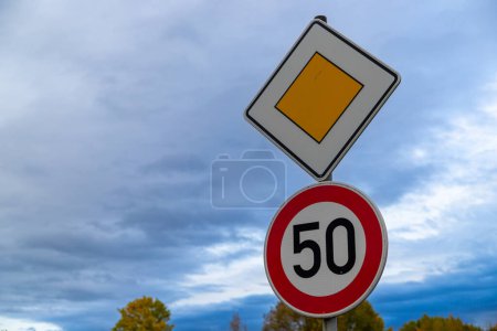 Photo for Road sign with 50 kroad sign with 50 kmh and right of way, Germany in autumnmh and right of way, Germany in autumn. High quality photo - Royalty Free Image