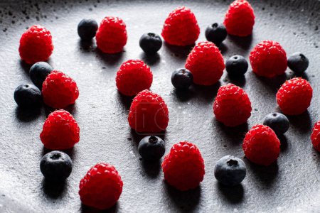 Foto de Raspberries, blueberries and cereals, the basis for a tasty healthy dessert - Imagen libre de derechos