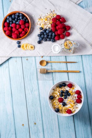 Foto de Tasty meal with yoghurt, banana, berries and cereals - Imagen libre de derechos