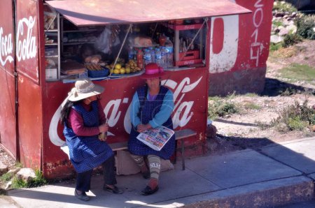 Téléchargez les photos : Andes, Altiplano - 18 juin 201 : Deux femmes autochtones assises près d'un stand à Altiplano, Andes. - en image libre de droit