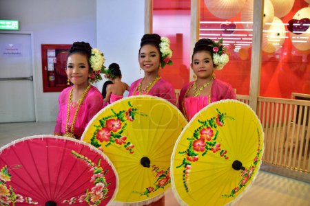 Téléchargez les photos : Portrait de jeunes femmes asiatiques en robes roses avec des parapluies dans une rangée - en image libre de droit