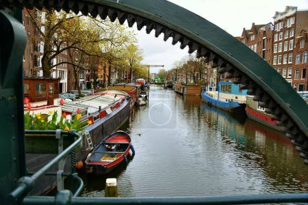 Foto de Ámsterdam, Países Bajos - 7 de abril de 2023: Hermosos canales de Ámsterdam rodeados de edificios históricos - Imagen libre de derechos