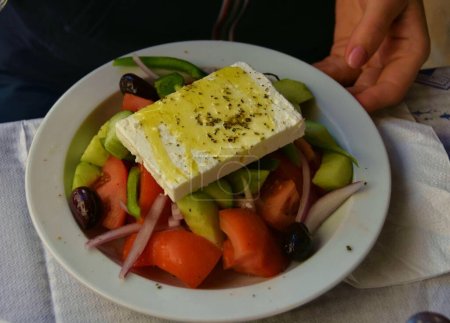 Foto de Ensalada griega fresca con queso local servida en taberna en la isla de Egina, Grecia - Imagen libre de derechos