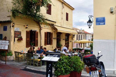 Foto de Atenas, Grecia, 18 de octubre de 2021: Personas descansando en un restaurante callejero en el distrito de Plaka en Atenas, Grecia. - Imagen libre de derechos