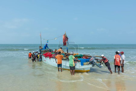Photo for Benaulim Beach, Goa - India. April, 06 2023. Fishermen unloading their catch from strawllers onto the shore. Fishermen then meticulously sort  segregate the fish according to their species and size. - Royalty Free Image