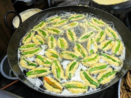 El pimiento verde frito en la sartén. Hora del té indio Snacks o Menasinakaayi, plato oriental tradicional.