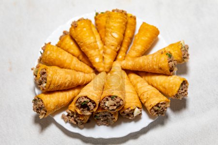 Foto de Snack tradicional para fiestas conocido como "canudinho" o "tatu tail". Relleno de carne molida y especias tradicionales. - Imagen libre de derechos