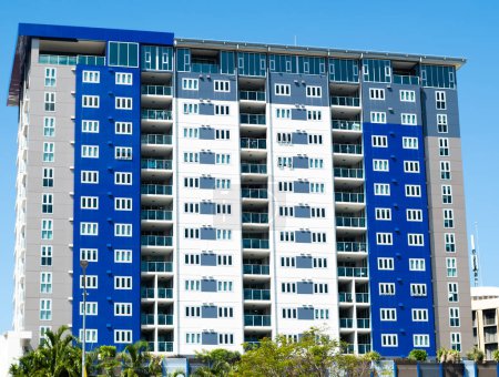 A blue, white and grey colored apartment block located in Darwin city, Australia, comprising a very simple design aesthetic.