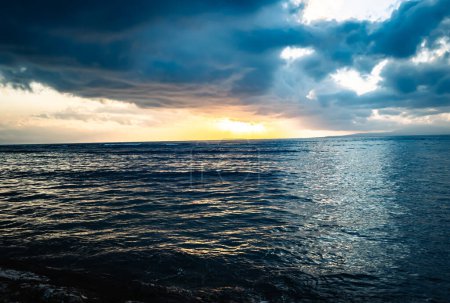 Téléchargez les photos : Des nuages sombres se rassemblent sur la plage de Sindhu Beach au lever du soleil à Sanur, Bali, Indonésie - en image libre de droit
