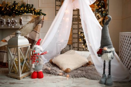 Foto de Decoración de Navidad y juguetes para Navidad y Año Nuevo. La casa de los niños. Muchas luces. Gnomo de juguete - Imagen libre de derechos