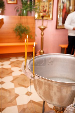 Foto de Candles and a cross in an Orthodox church during the Sacrament of Baptism - Imagen libre de derechos