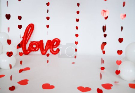 Foto de Red paper hearts on a white background for Valentine's Day. Balls with the word love - Imagen libre de derechos