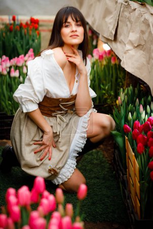 Foto de Elegante joven jardinero cultivando tulipanes y macetas para la venta en casa - Imagen libre de derechos