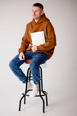 Foto de Joven especialista en TI con un portátil en la oficina sobre un fondo blanco - Imagen libre de derechos