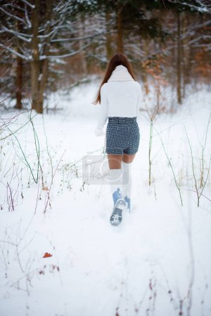 Chica caminando en el bosque con ropa elegante