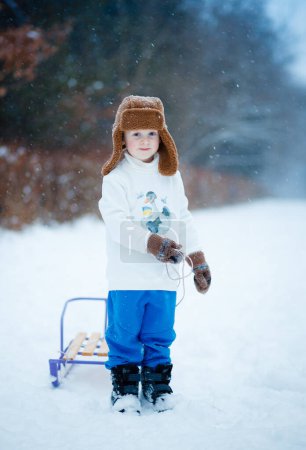 Foto de Ropa de invierno para niños cálidos. Producción ucraniana durante la guerra. Un paseo por un bosque nevado - Imagen libre de derechos