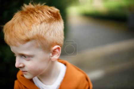 Horizontal portrait of a red-haired boy in sportswear