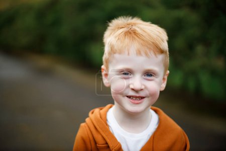 Foto de Retrato de un chico pelirrojo que sonríe. Ojos azules y un traje elegante - Imagen libre de derechos