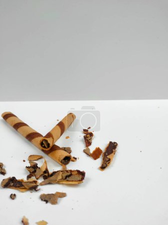 Crispy chocolate wafer roll sticks with crumb isolated on white background
