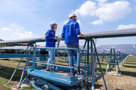 Photo for Maintenance engineers at solar farm stand on scissor lift, routine inspection of solar panels condition - Royalty Free Image
