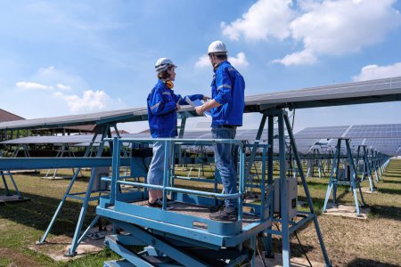 Photo for Maintenance engineers at solar farm stand on scissor lift, routine inspection of solar panels condition - Royalty Free Image