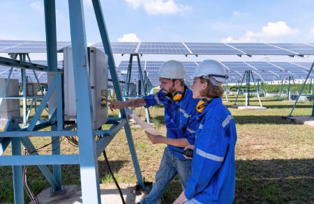 Téléchargez les photos : Ingénieurs d'entretien à la ferme solaire dépannage et à la recherche d'onduleur panneau de commande - en image libre de droit