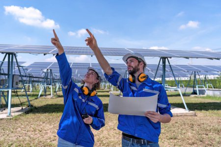 Foto de Ingenieros de mantenimiento en la granja solar mirando dibujo discutir sobre la ampliación actualizar la planta de electricidad - Imagen libre de derechos