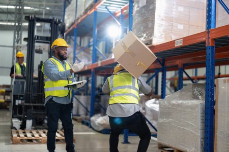 Photo for African americans working in warehouse got accident from carry box, forklift truck working near by - Royalty Free Image