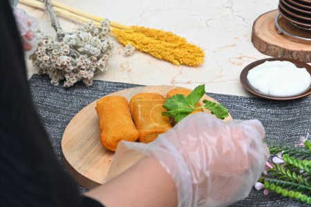 Téléchargez les photos : Une employée prépare des gâteaux de mayonnaise risol (en indonésienne appelée mayo Risol) pour la séance photo avec quelques accessoires - en image libre de droit