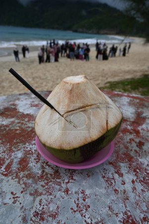Téléchargez les photos : Noix de coco fraîches avec une atmosphère de plage pendant les vacances. - en image libre de droit
