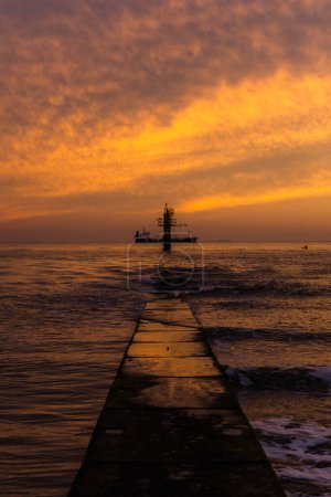 Photo for Sunset over the North Sea with a ship and weather station. - Royalty Free Image