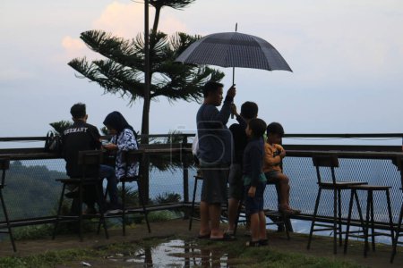 Téléchargez les photos : Semarang, December 2022. view of visitors to the umbul sidomukti coffee cottage cafe enjoying food and natural scenery that is cool and fresh - en image libre de droit